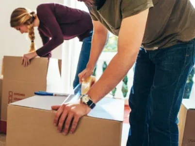 Couple packing boxes, symbolizing the organization of probate estate belongings after death. Contact Kid Breukelen Realty Group for guidance